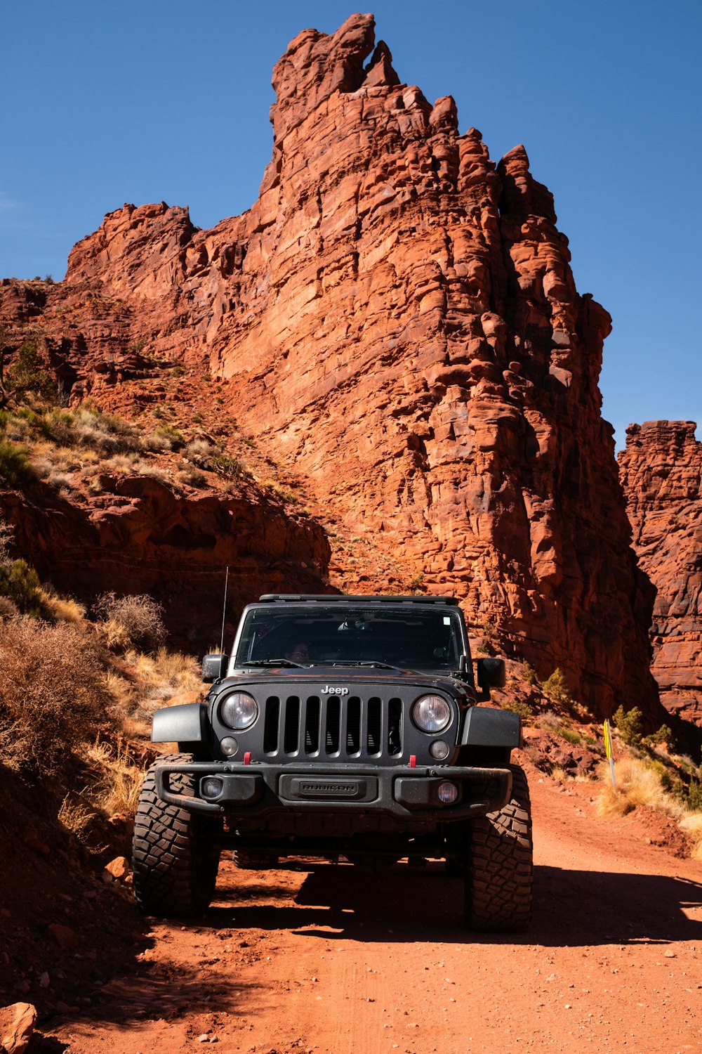 a jeep driving down a dirt road in the desert