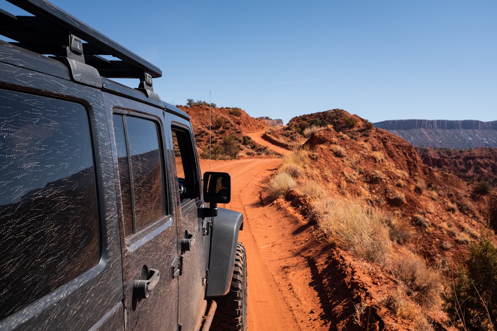 a jeep driving down a dirt road in the desert