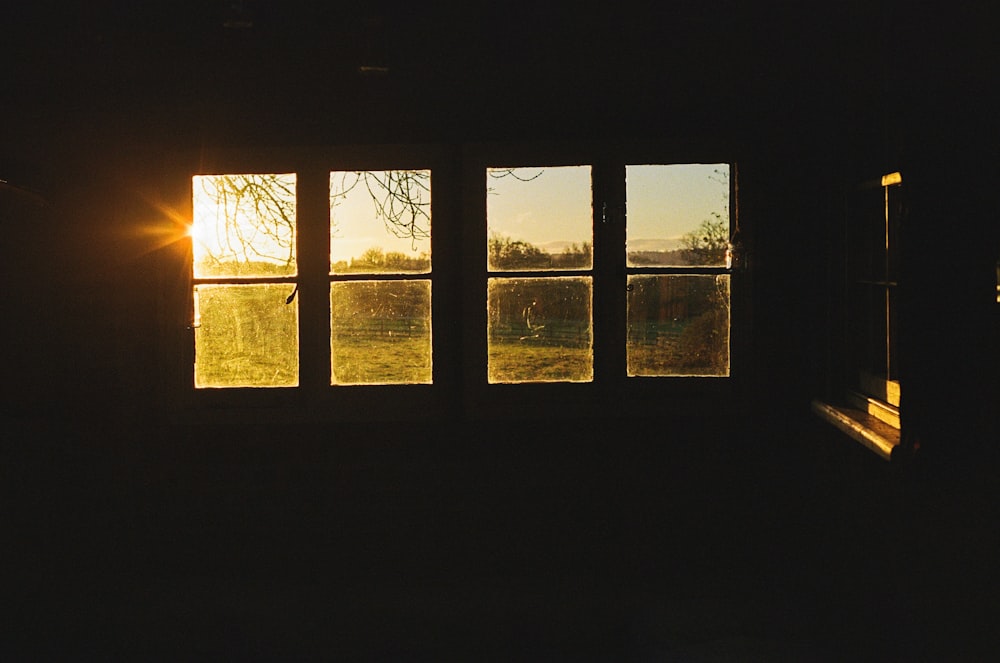 El sol brilla a través de una ventana en una habitación oscura