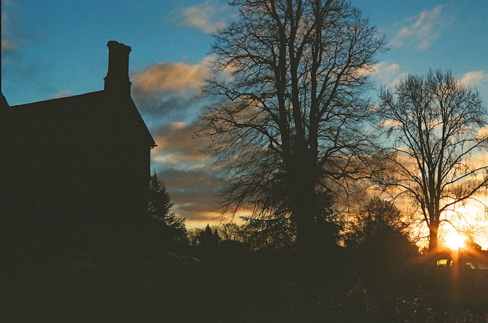 the sun is setting behind some trees