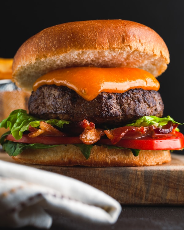 A cheeseburger with bacon, lettuce and tomato