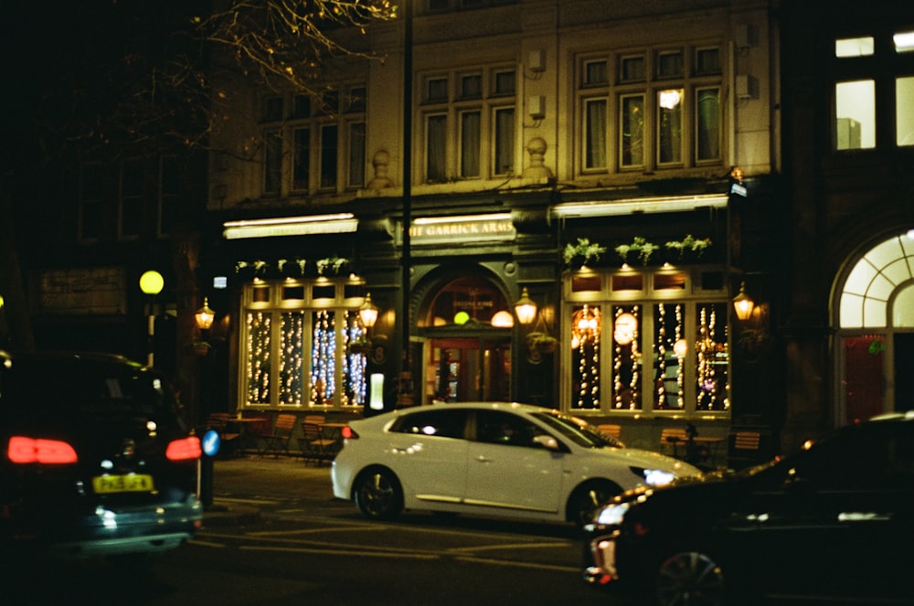 a car parked in front of a building at night