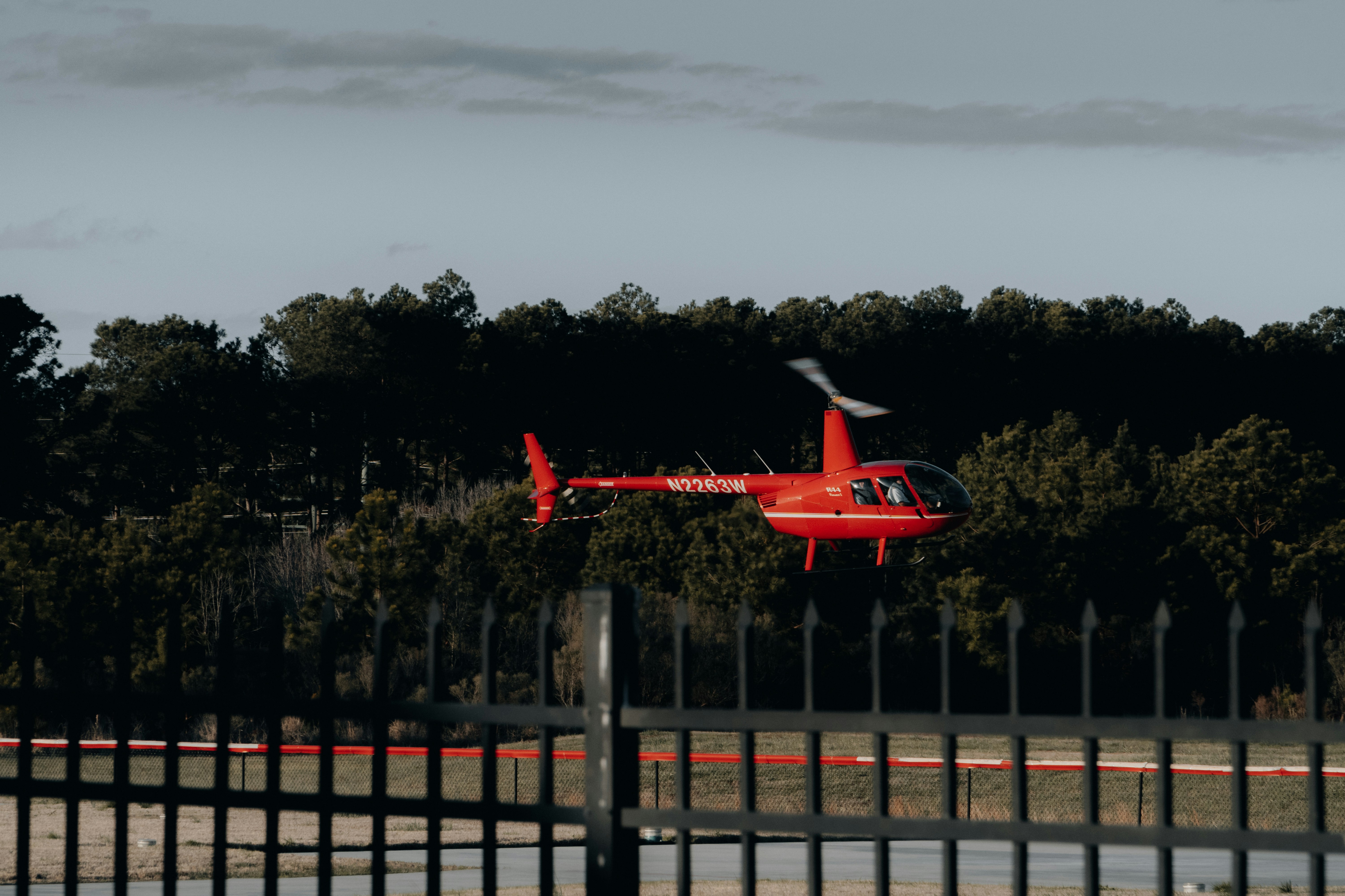 Un helicóptero rojo sobrevuela una valla