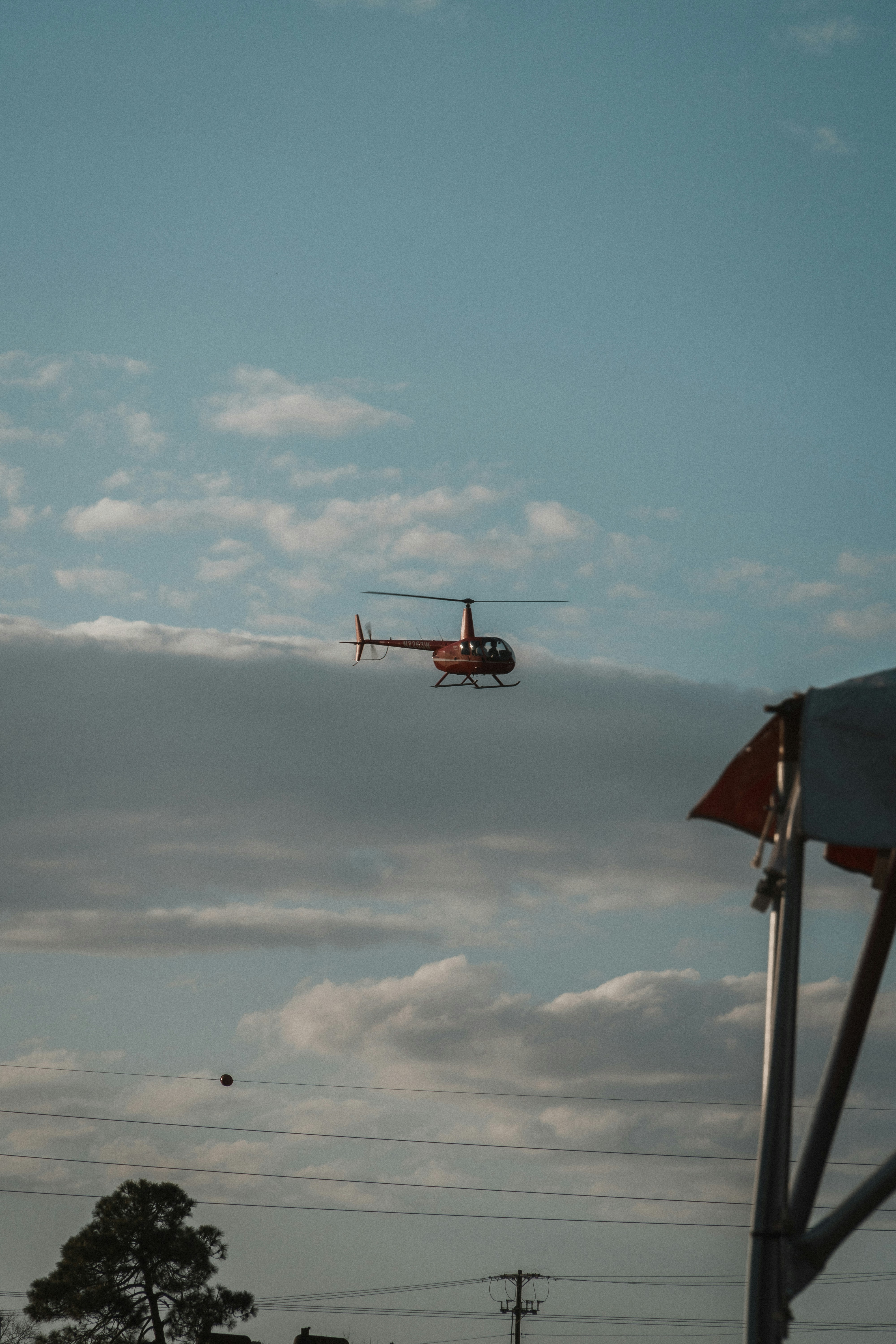 a helicopter flying through a cloudy blue sky