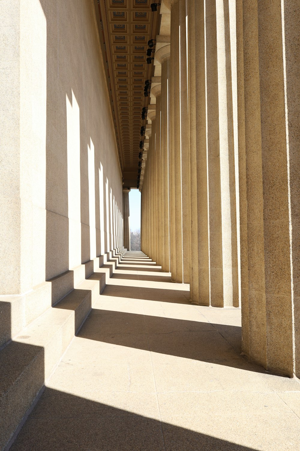 uma longa fileira de colunas ao lado de um edifício