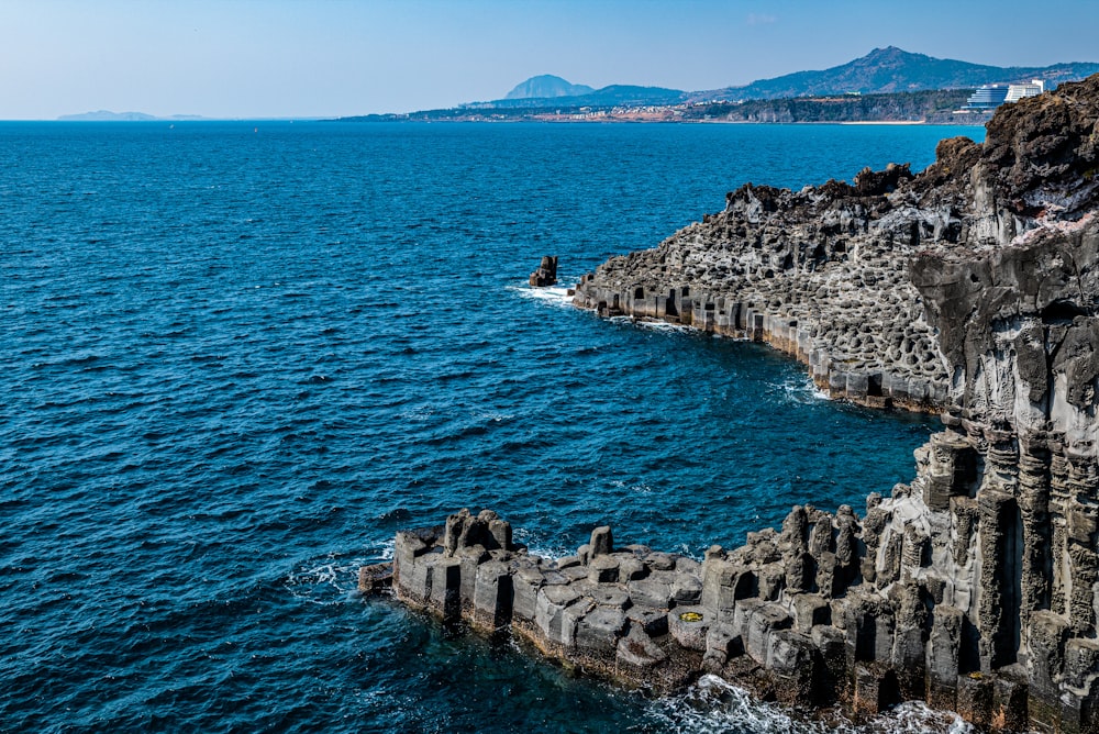 a large body of water next to a rocky shore