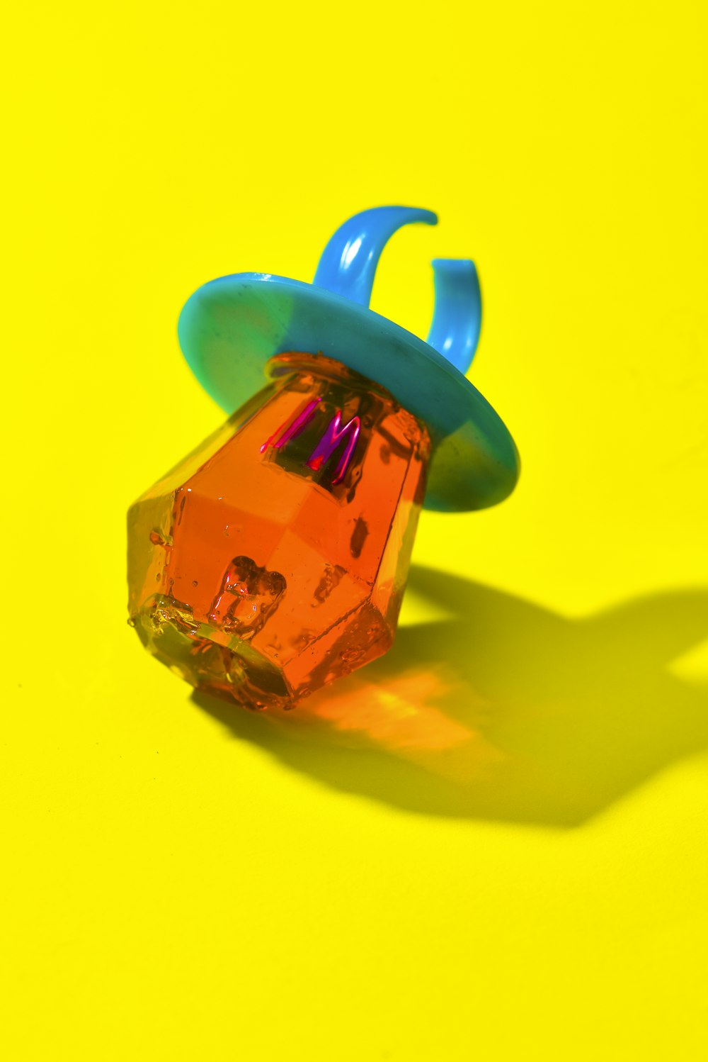 um objeto de plástico sentado em cima de uma superfície amarela