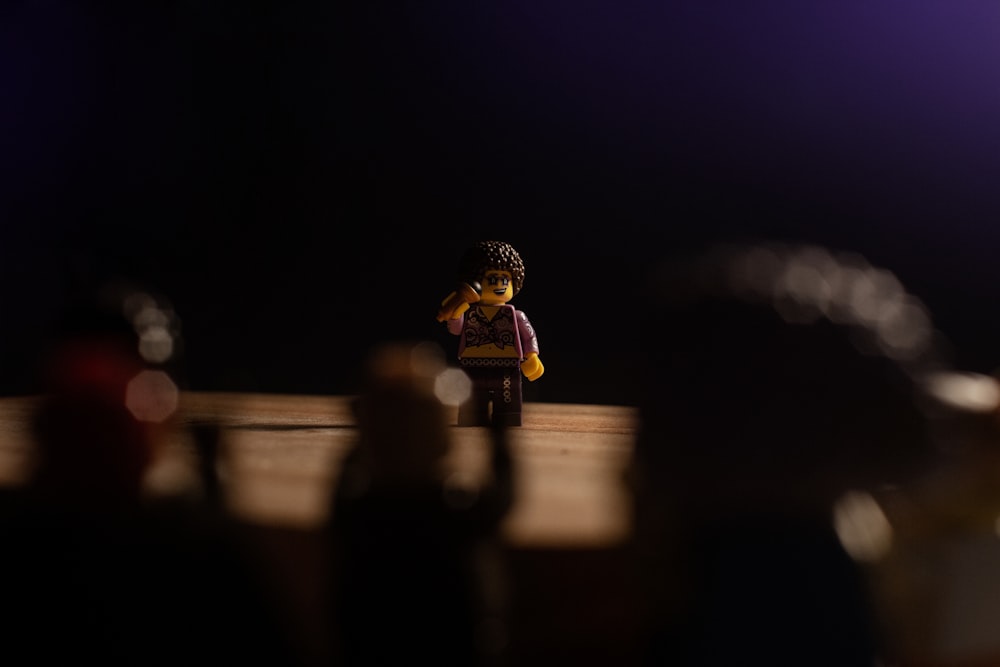 a lego man sitting on top of a wooden table