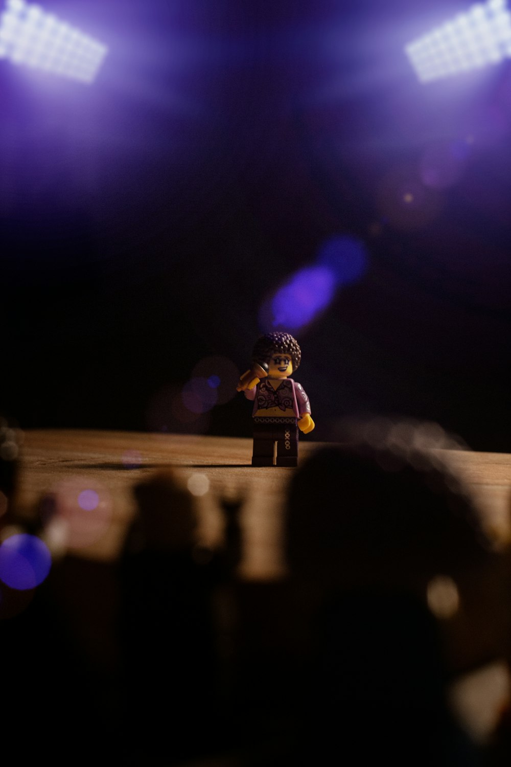 a lego man standing on a stage in front of a crowd