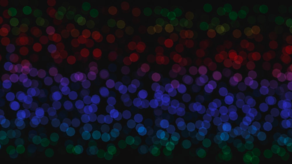 a blurry image of colorful lights on a black background