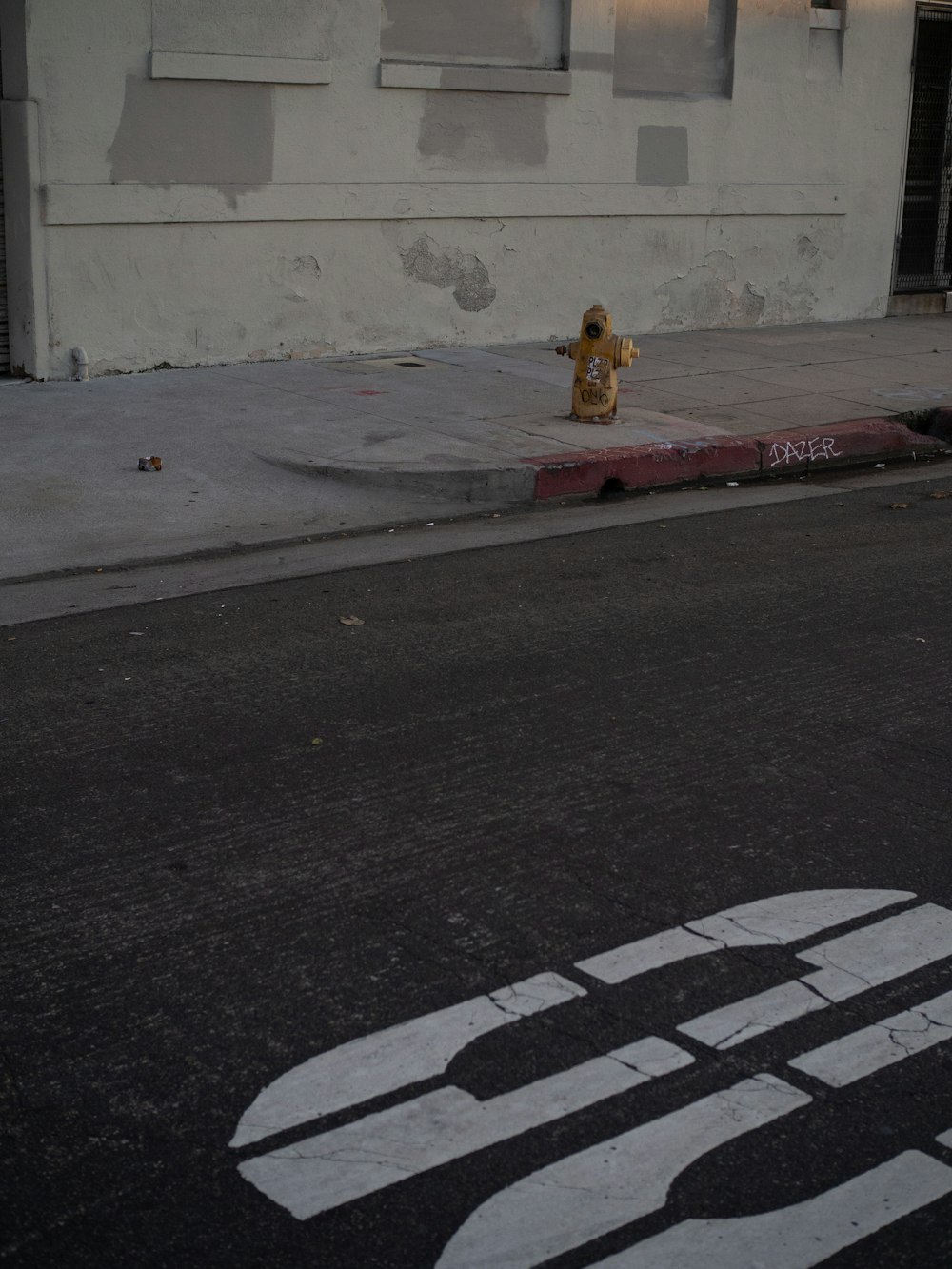 a yellow fire hydrant sitting on the side of a road