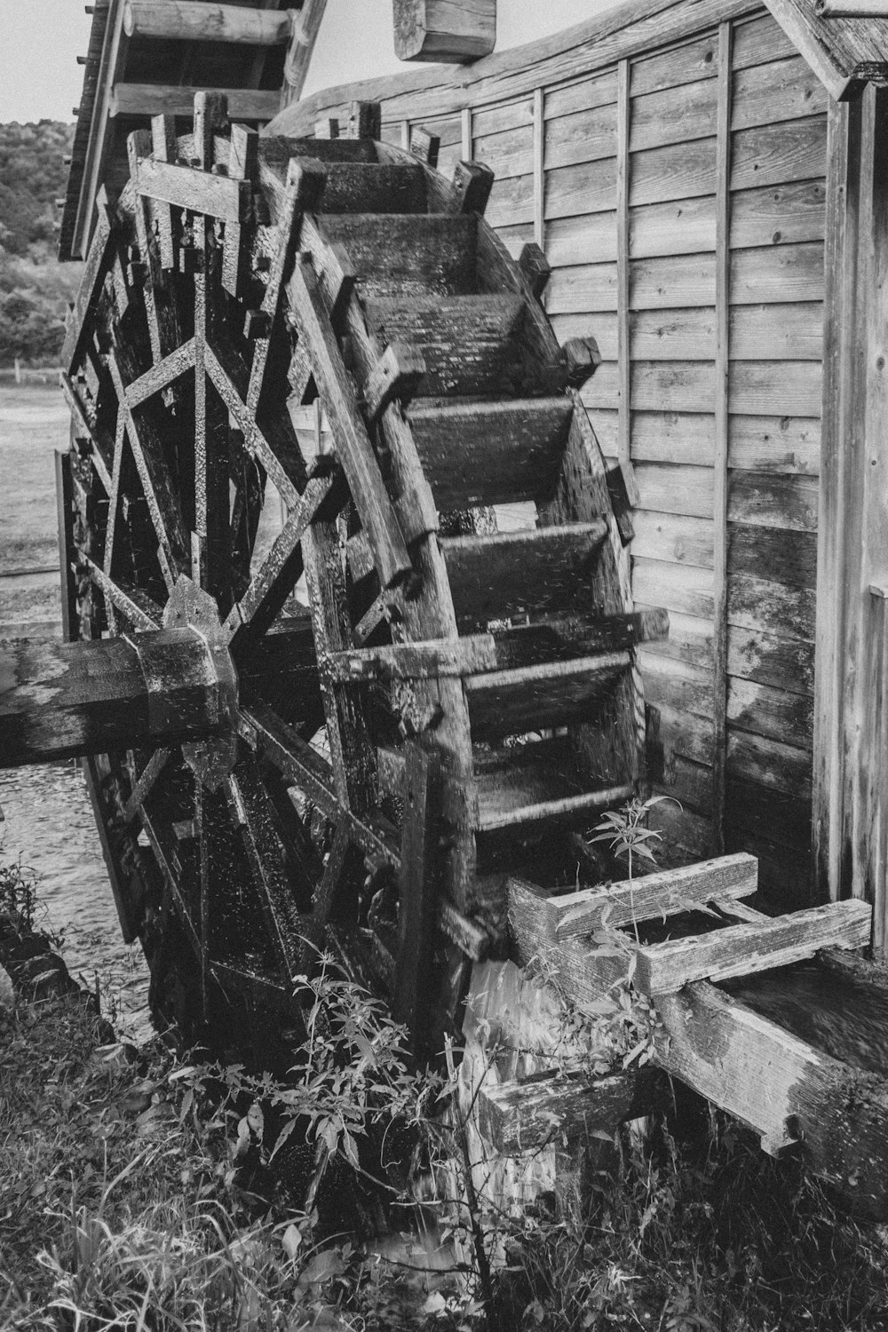 a black and white photo of a water wheel