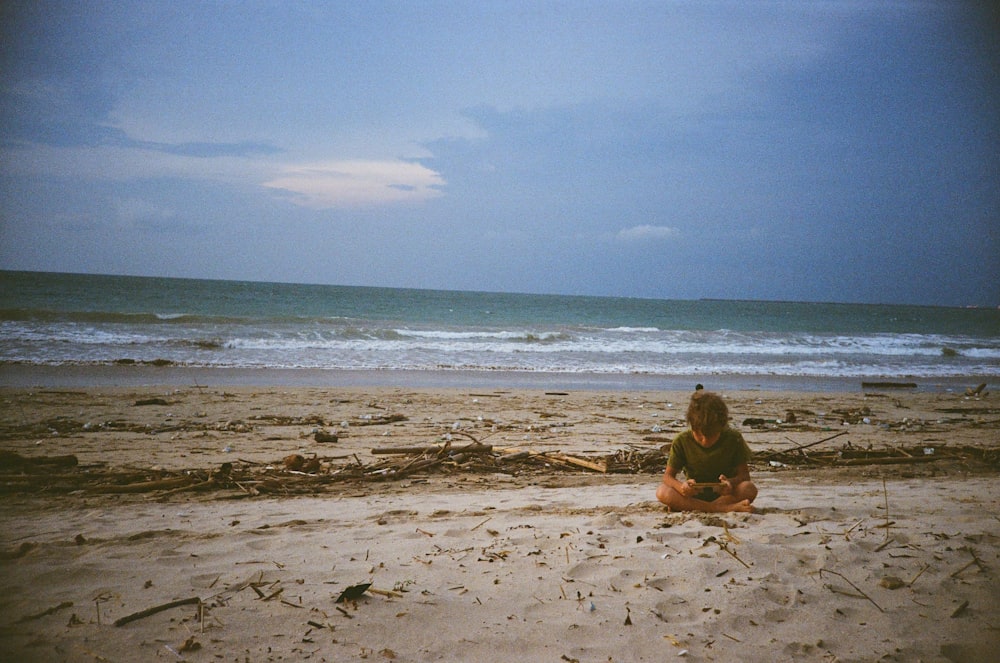 a person sitting in the sand on a beach