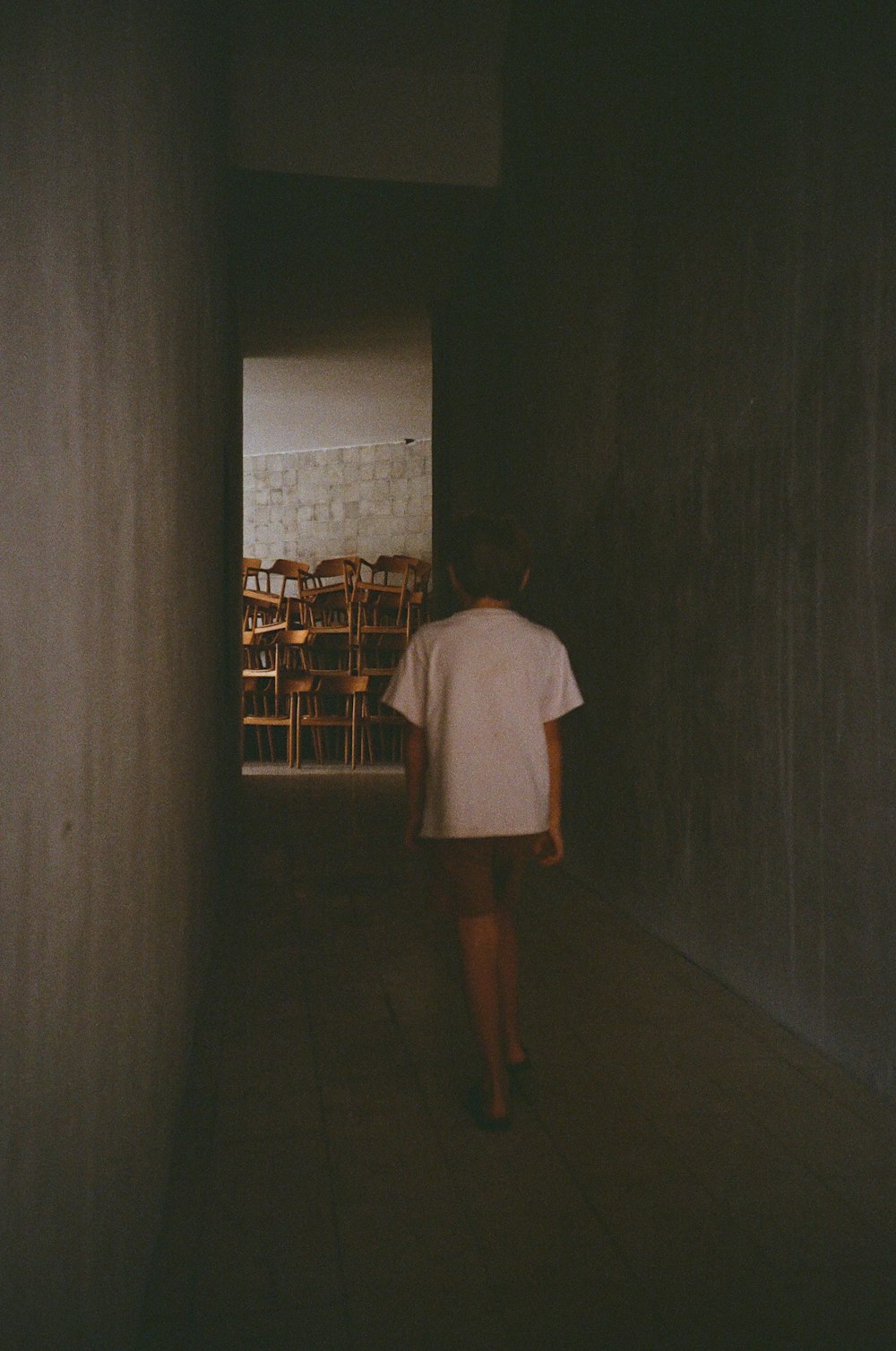 a person is walking down a dark hallway