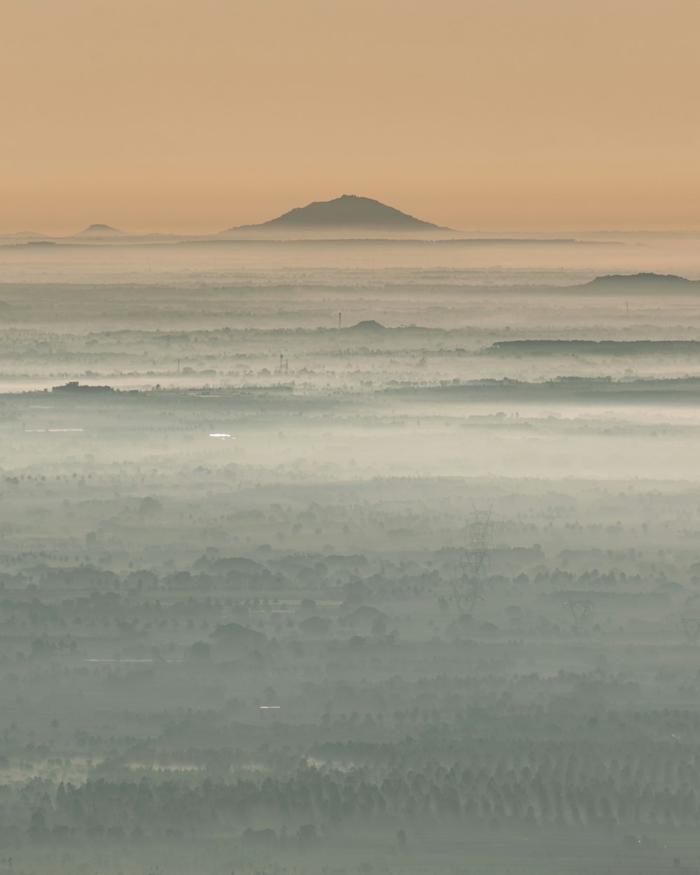 uma paisagem nebulosa com uma pequena ilha à distância