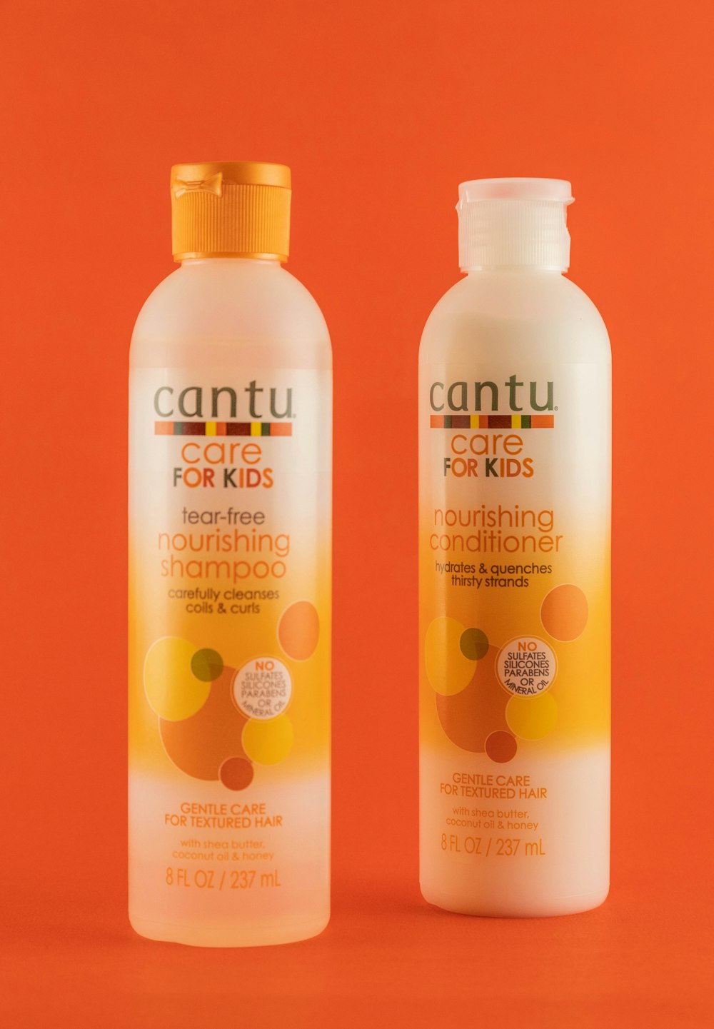 zwei Flaschen Shampoo auf orangefarbenem Hintergrund
