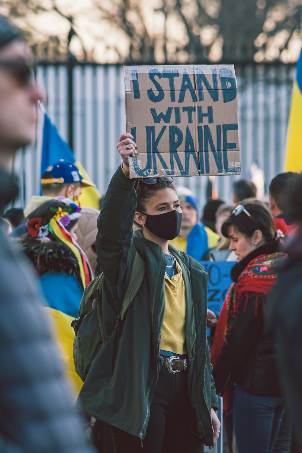 a person holding a sign that says i stand with ukraine