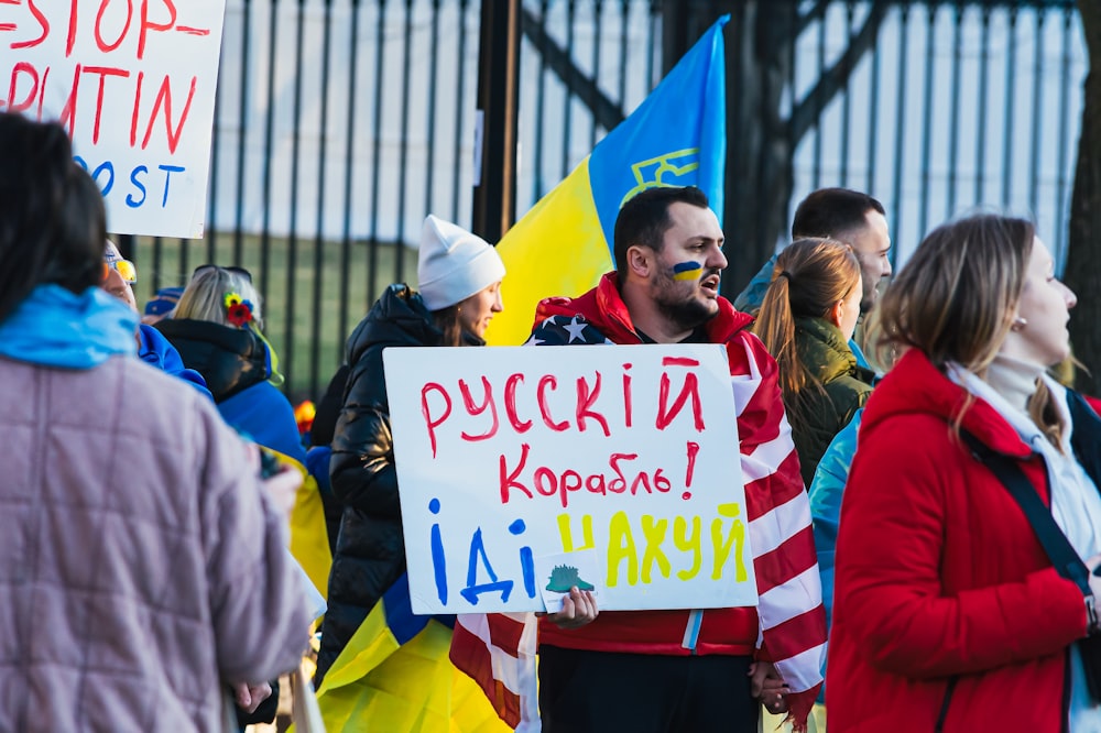 a group of people standing around holding signs