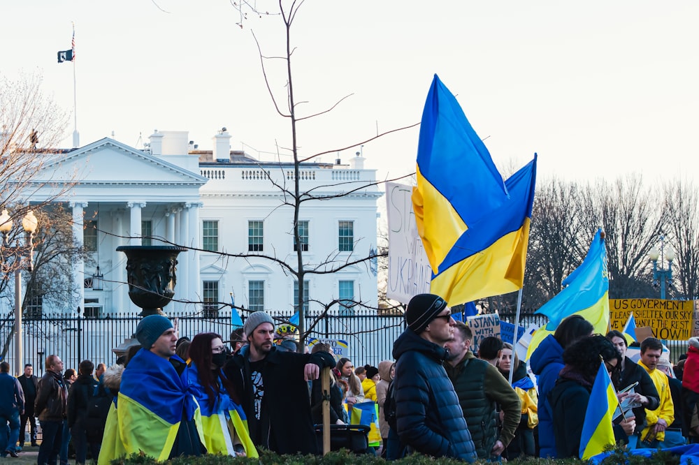 a group of people standing in front of a white house