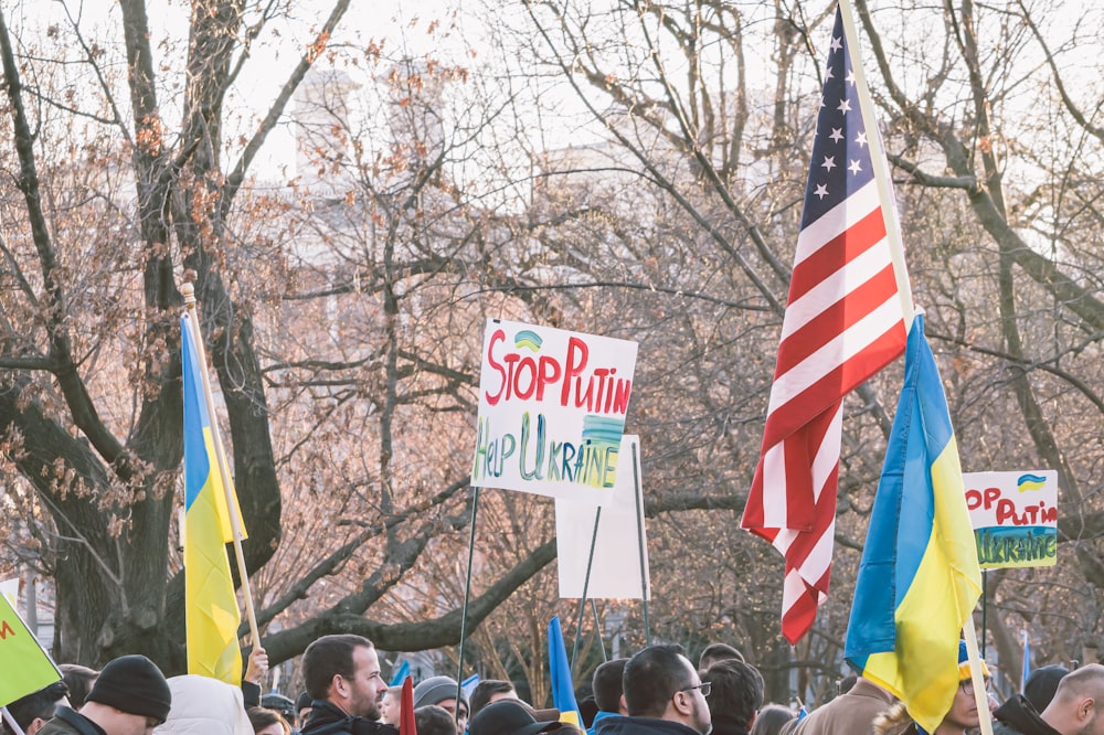 a crowd of people holding signs and flags