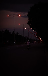 a man riding a motorcycle down a street at night
