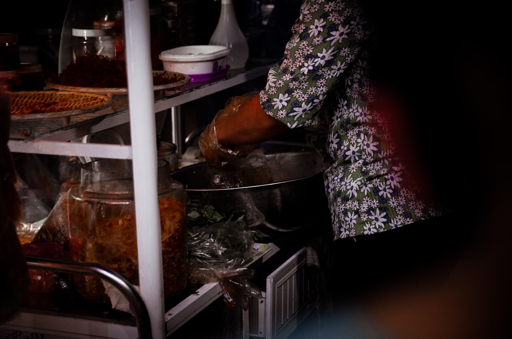 a woman cooking food in a pot on top of a stove