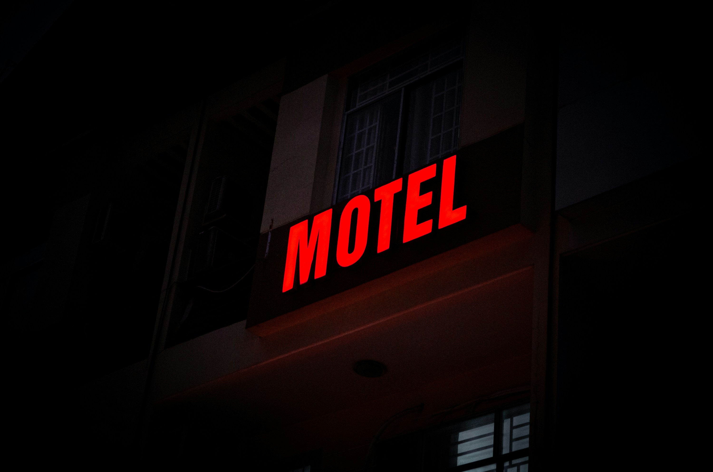 a hotel sign lit up in the dark