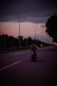 a man riding a motorcycle down a street at night