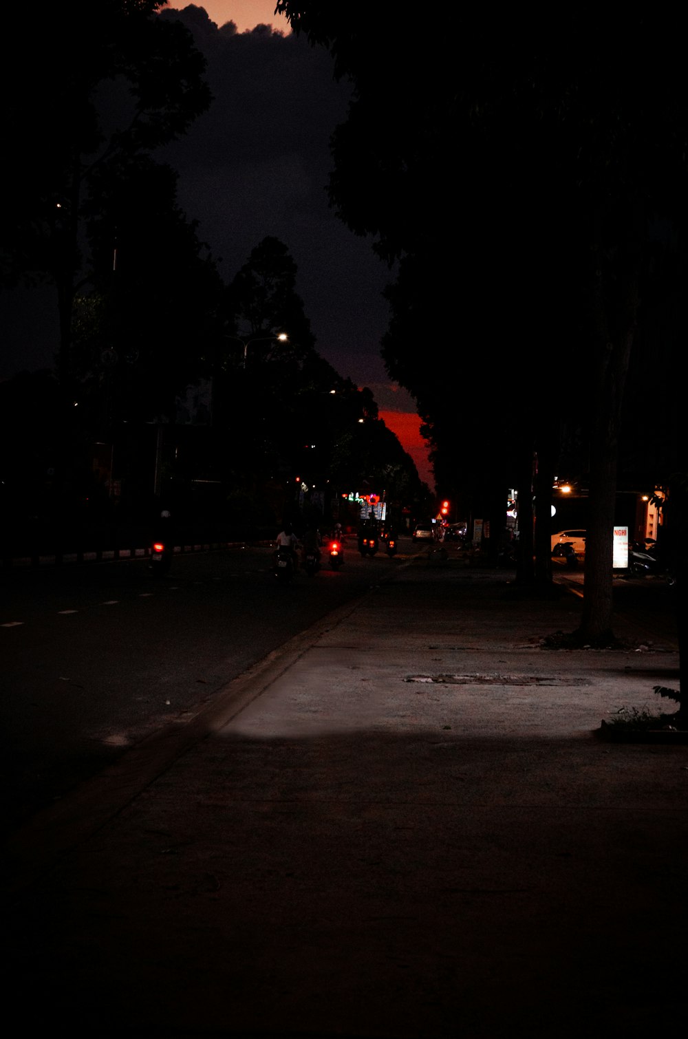 a dark street at night with a street light on
