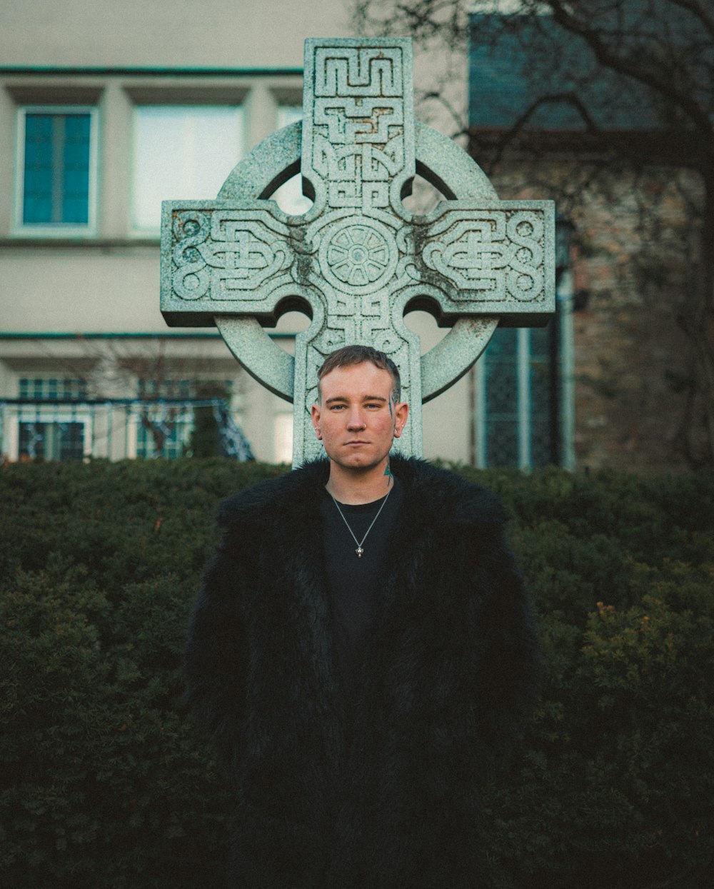 a man standing in front of a cross