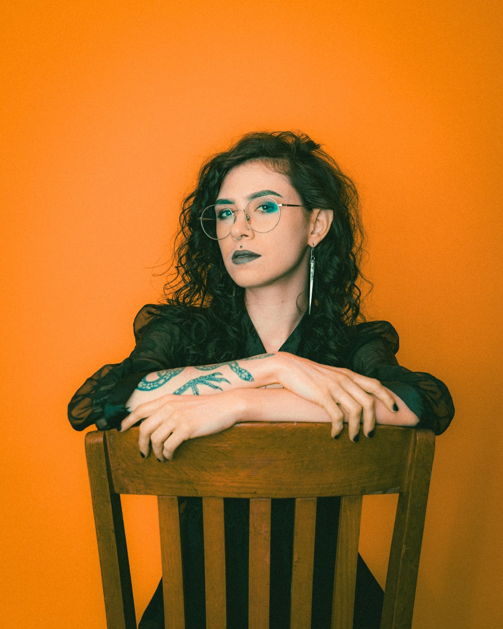 a woman sitting in a chair with her arms crossed