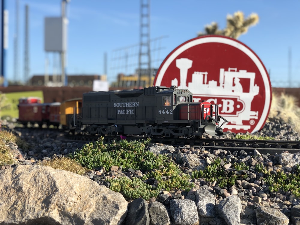 a model train on a track with a sign in the background