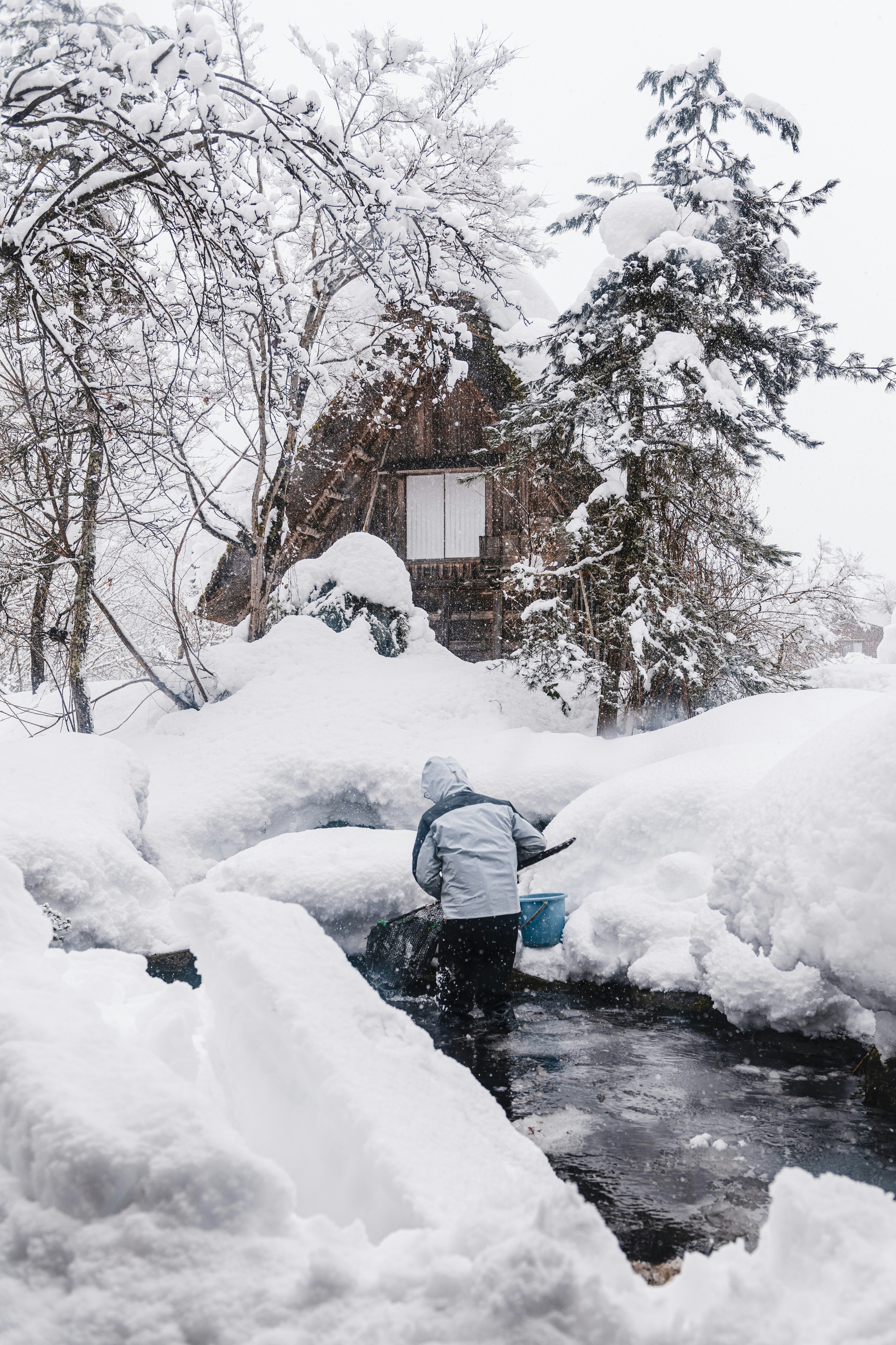 눈으로 둘러싸인 개울에 서있는 사람