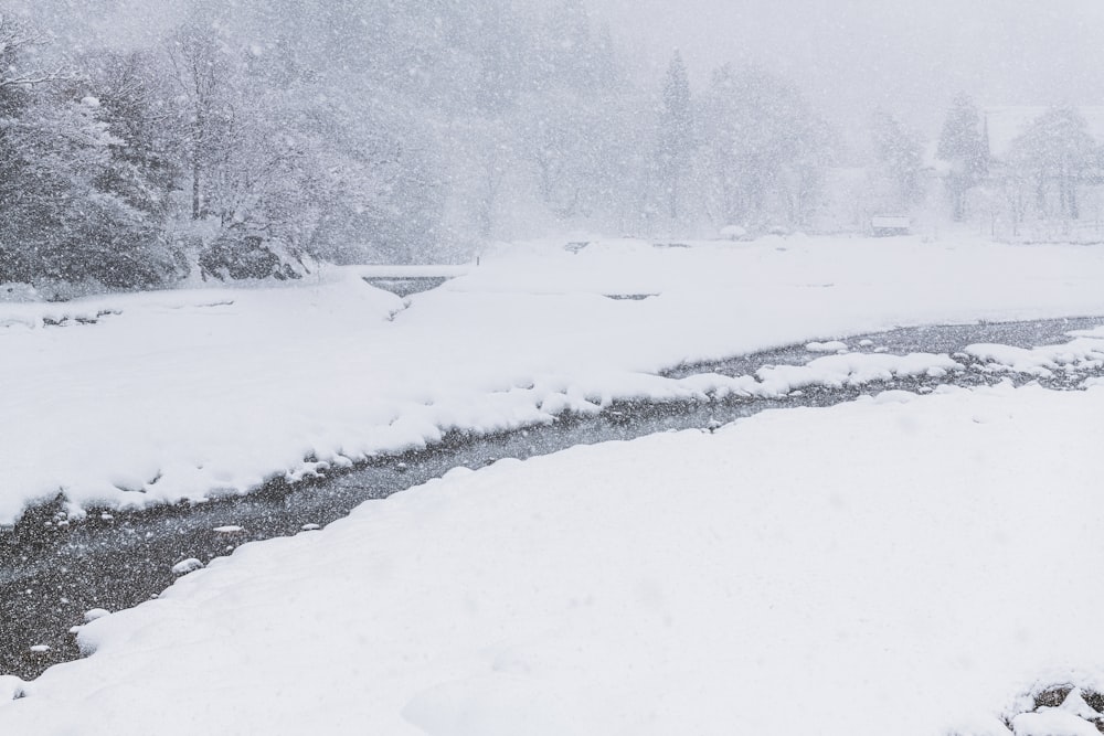 a man standing on a snow covered bank next to a river