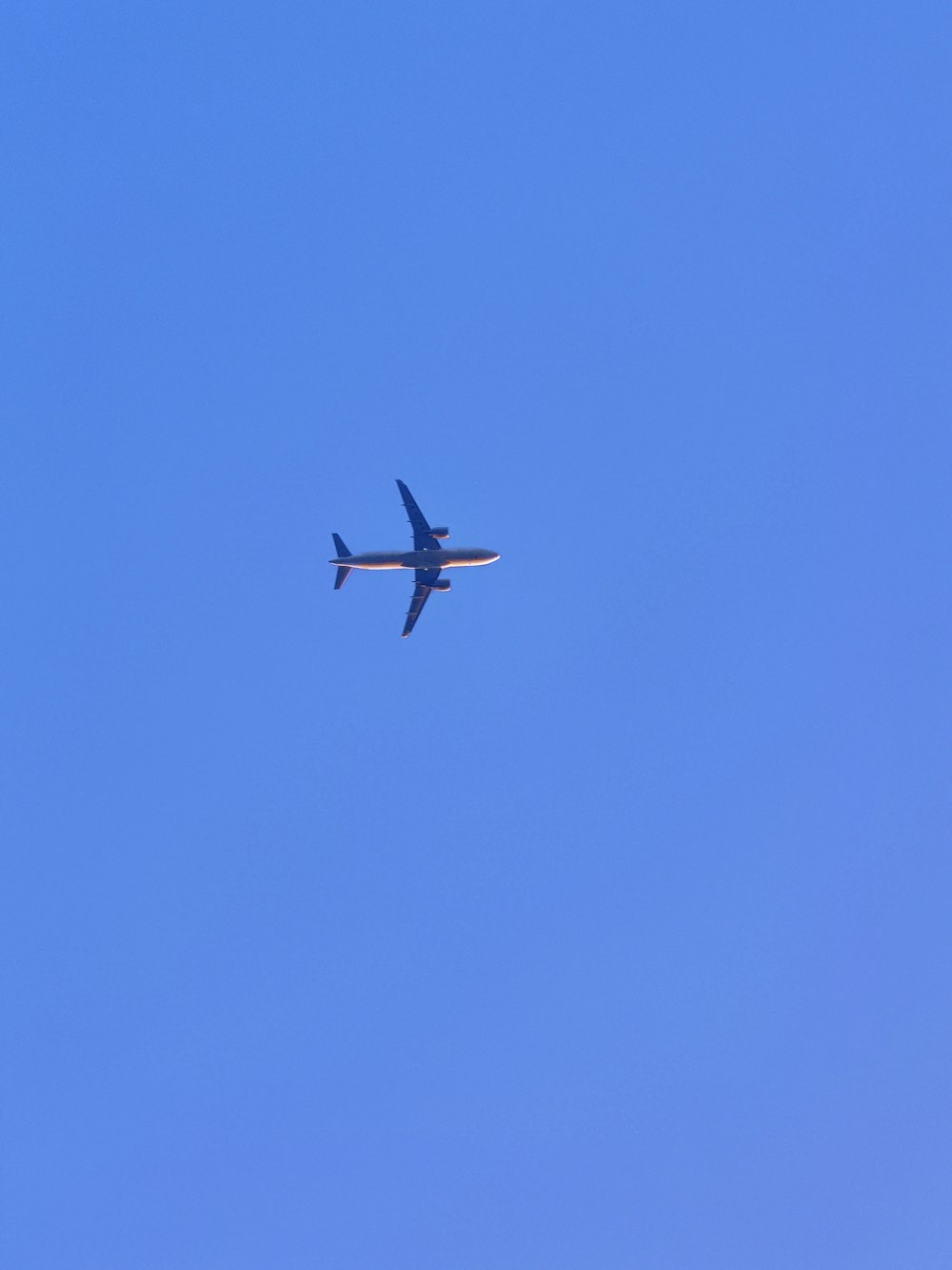 an airplane is flying in the blue sky