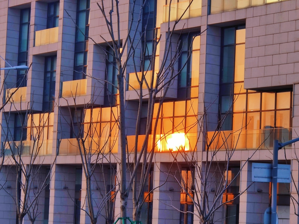 the sun is setting behind the windows of a building