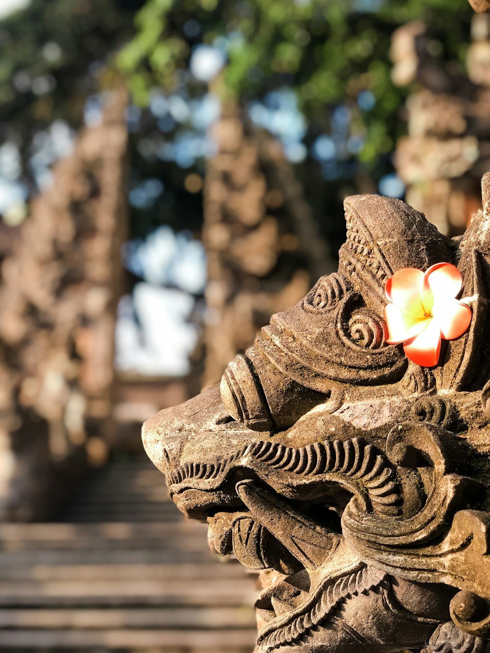 a close up of a statue with a flower on it