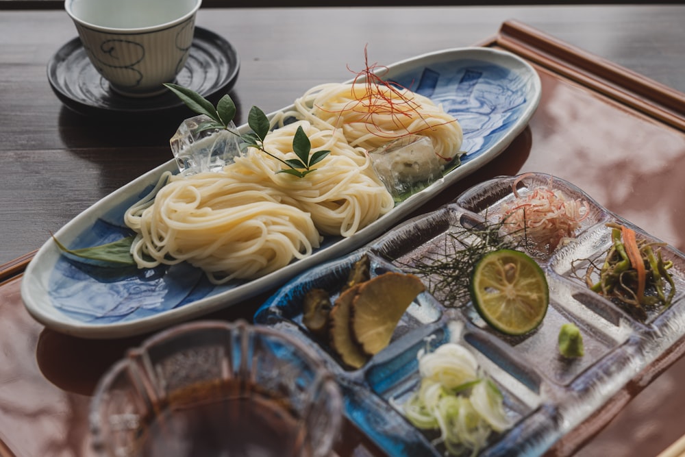 a tray of food with noodles and vegetables