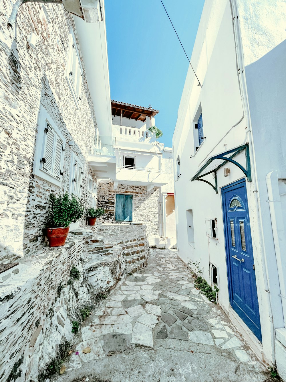 a cobblestone street with a blue door and window