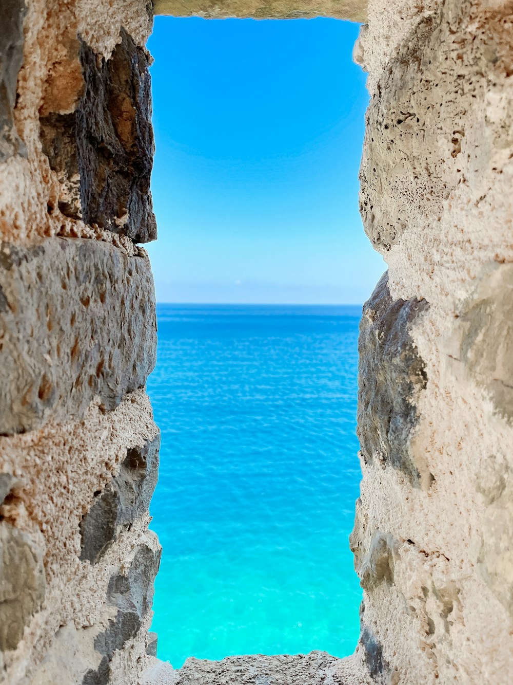 a view of the ocean through a stone window