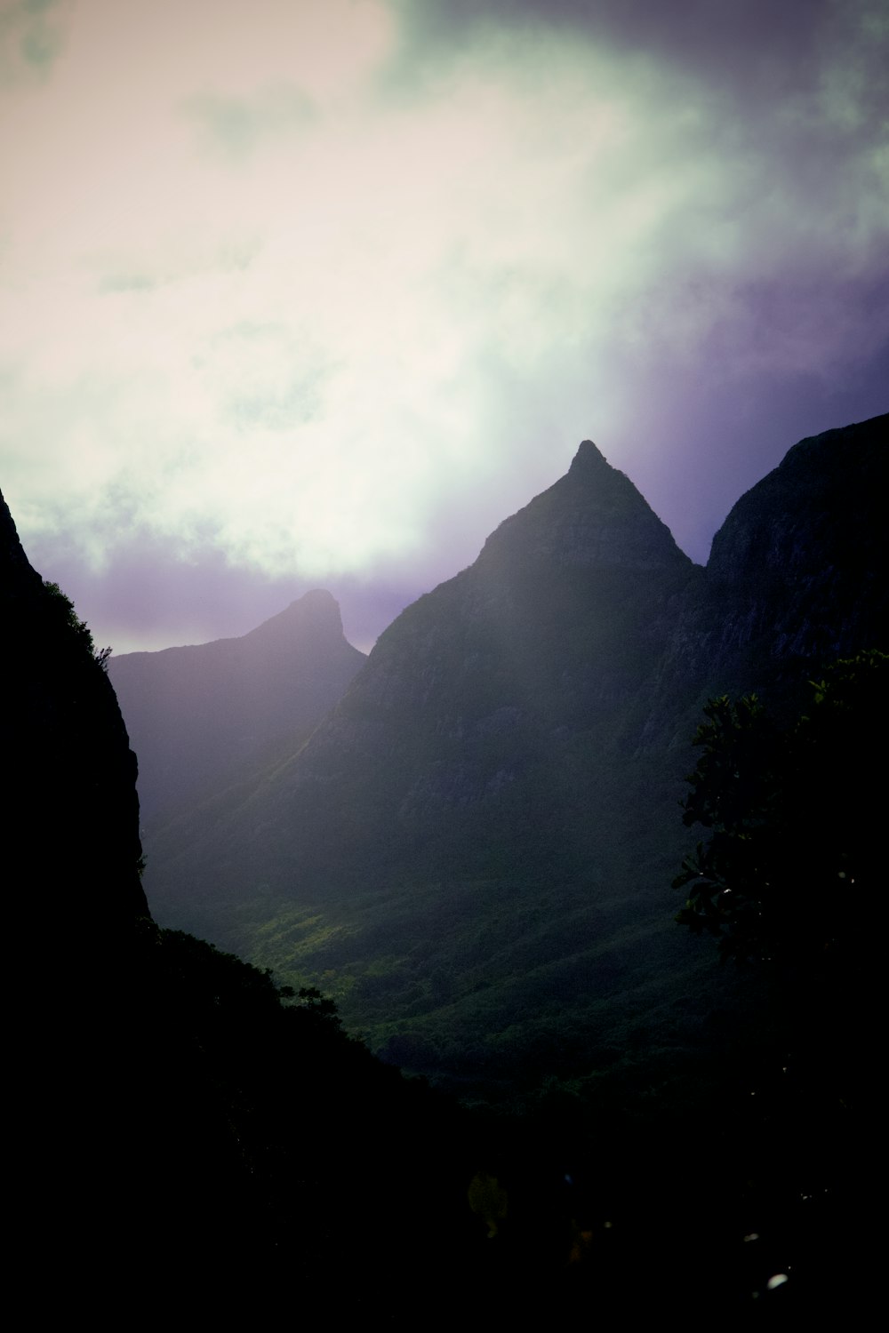 the sun is shining through the clouds over the mountains