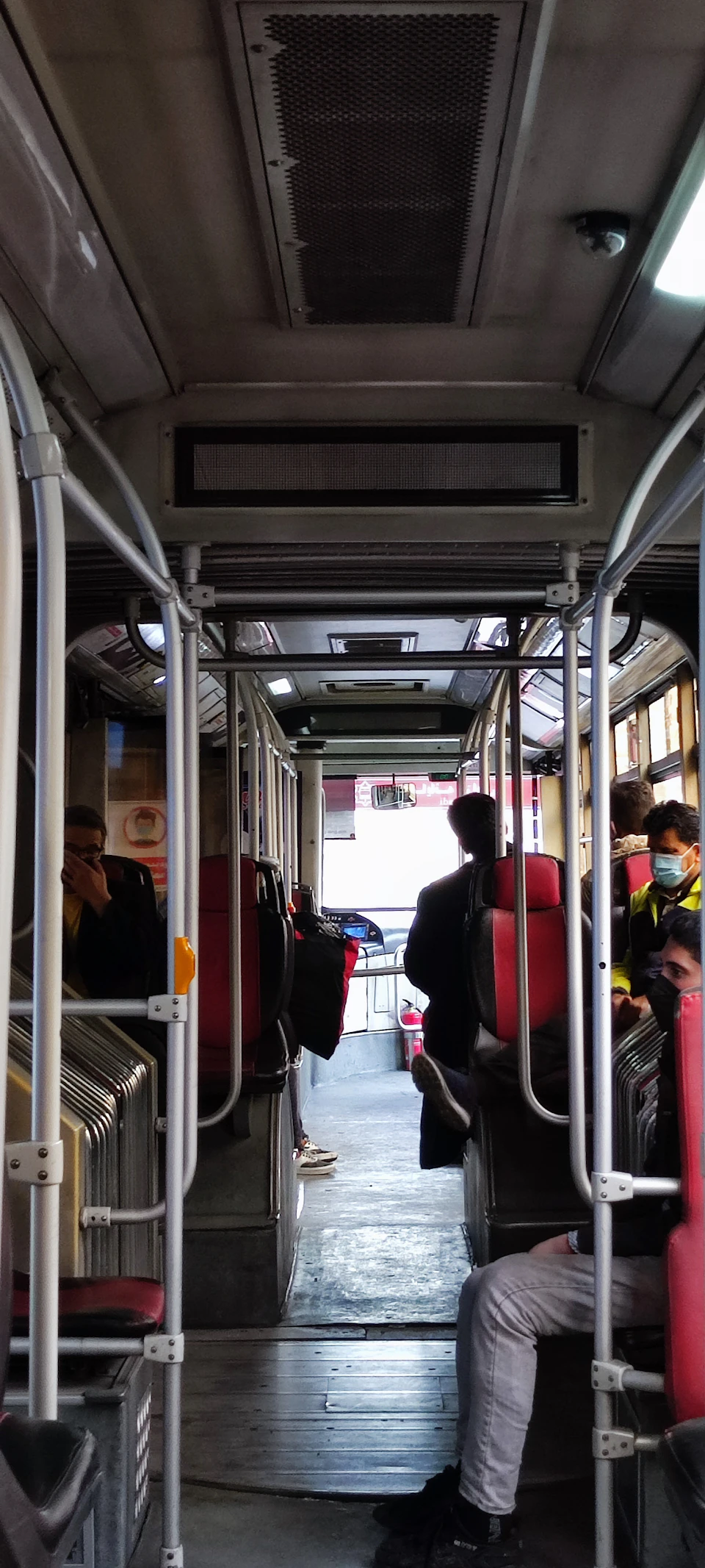 Gray ceiling and white walls contrast with red seats lining both sides of the aisle