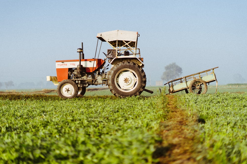 a tractor pulling a trailer behind it in a field