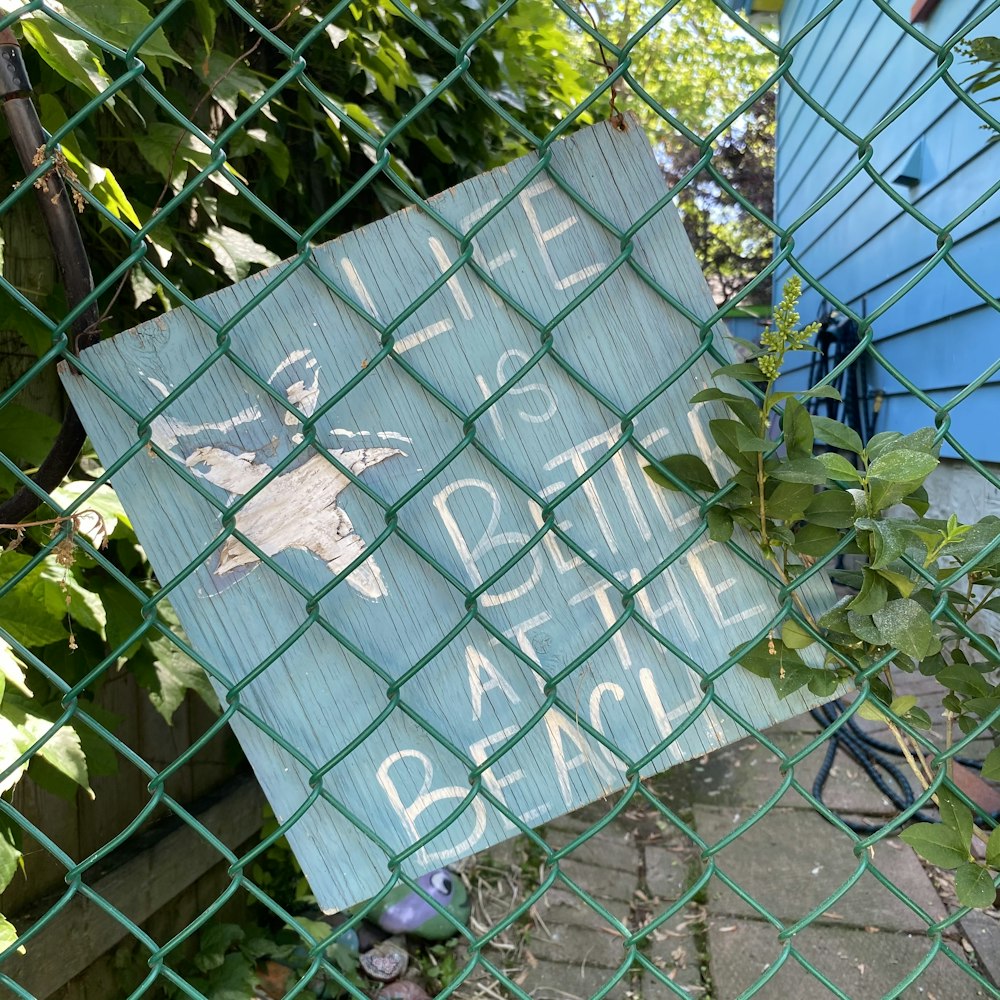a sign on a chain link fence that says please close to the beach