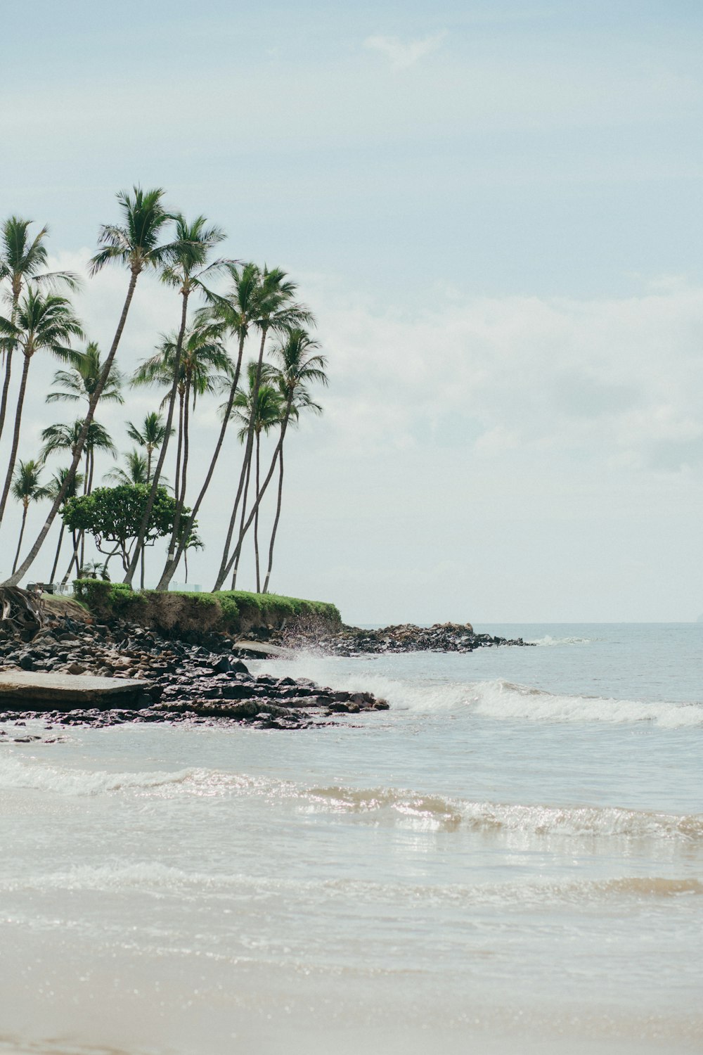 a man riding a surfboard on top of a sandy beach