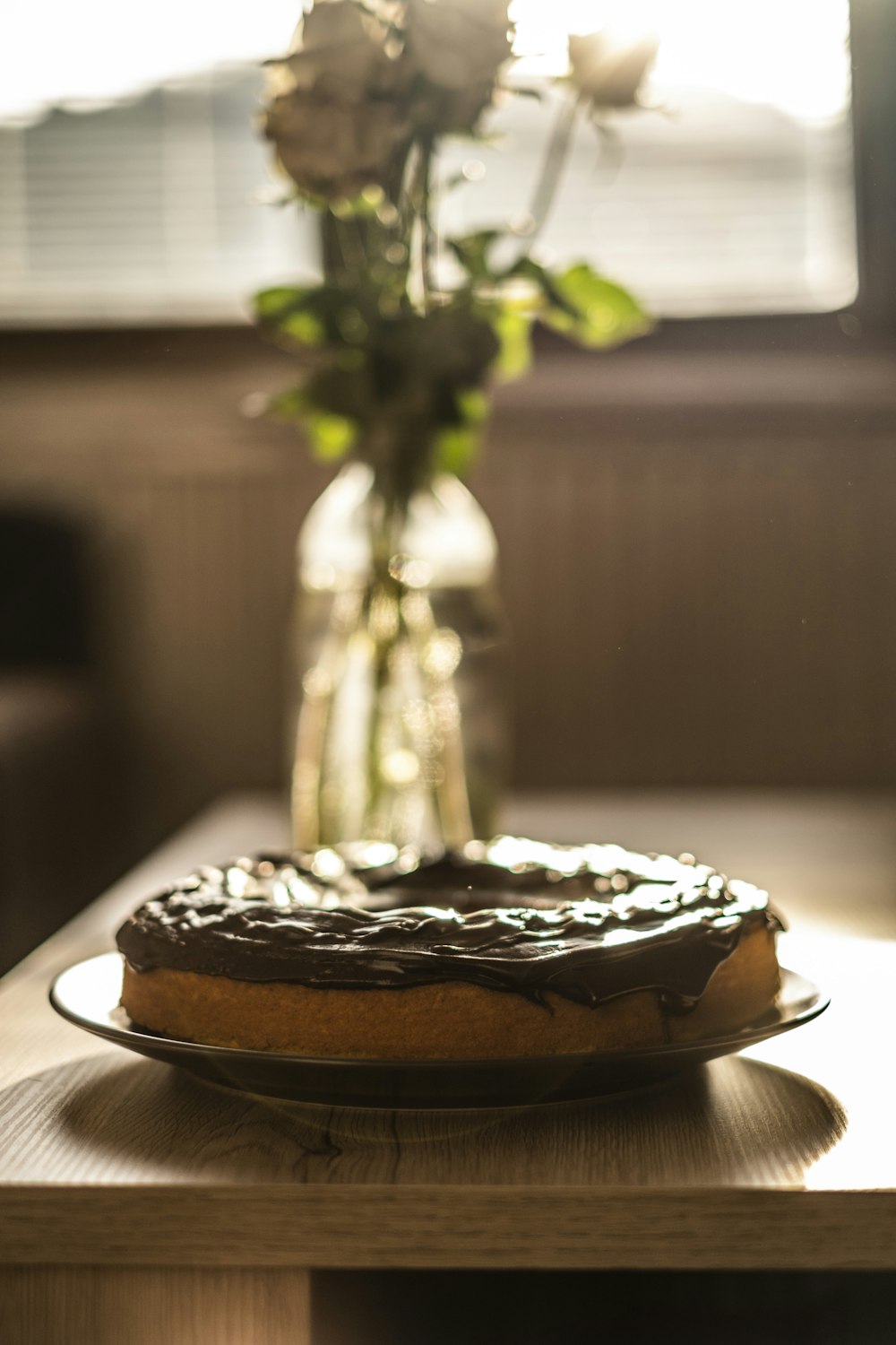 a cake sitting on a table next to a vase of flowers