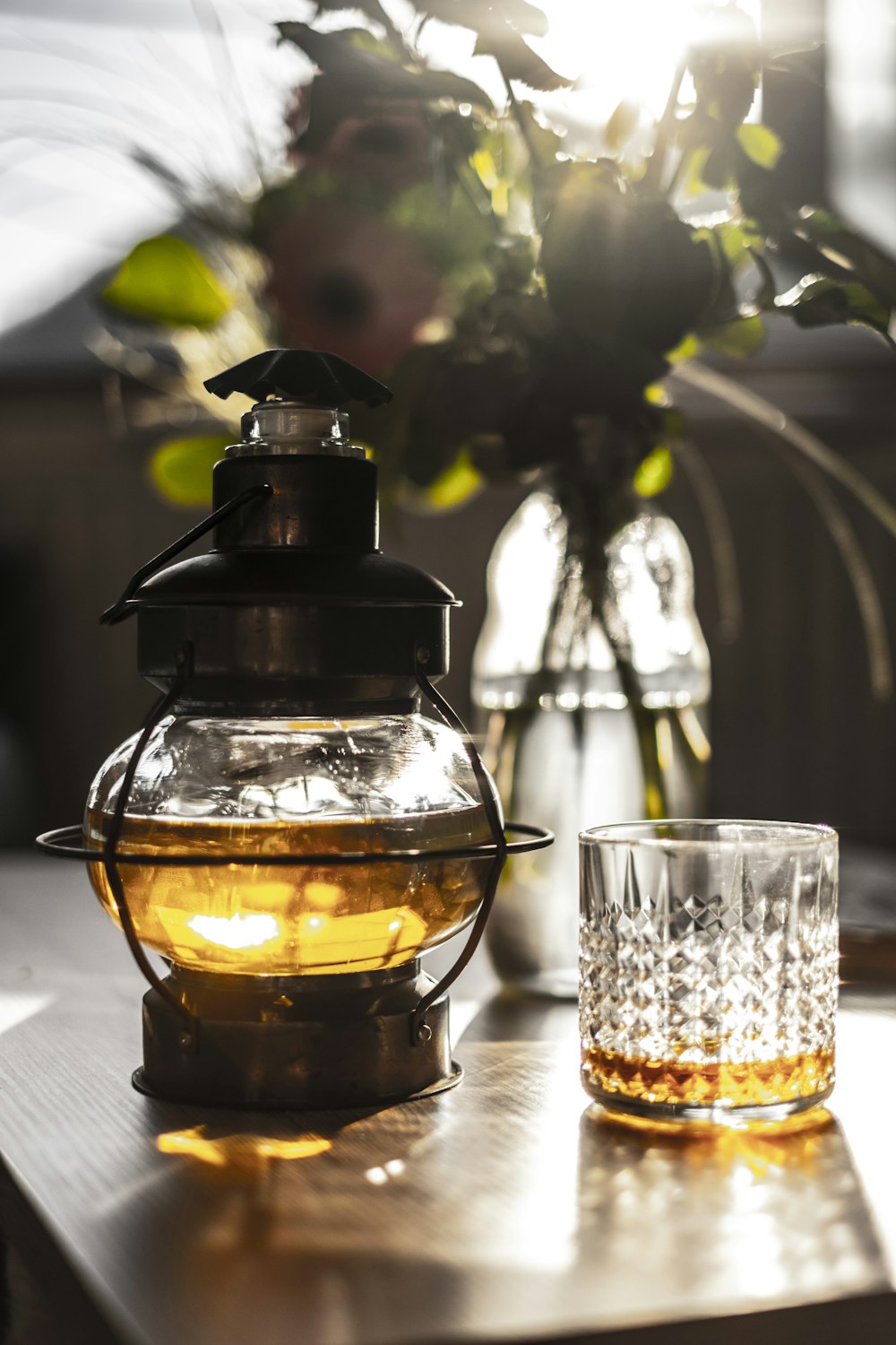 a vase of flowers and a glass on a table