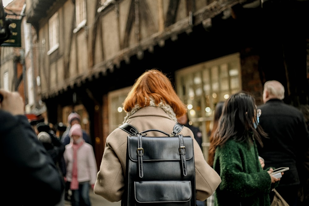 a woman with red hair is walking down the street