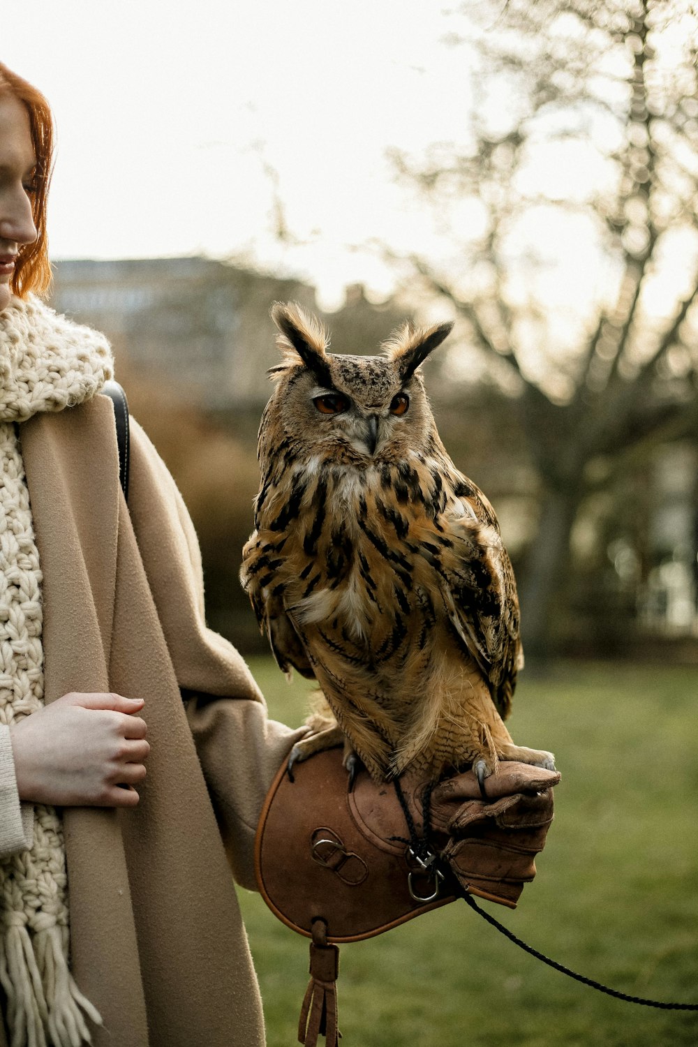 a woman holding an owl on a glove