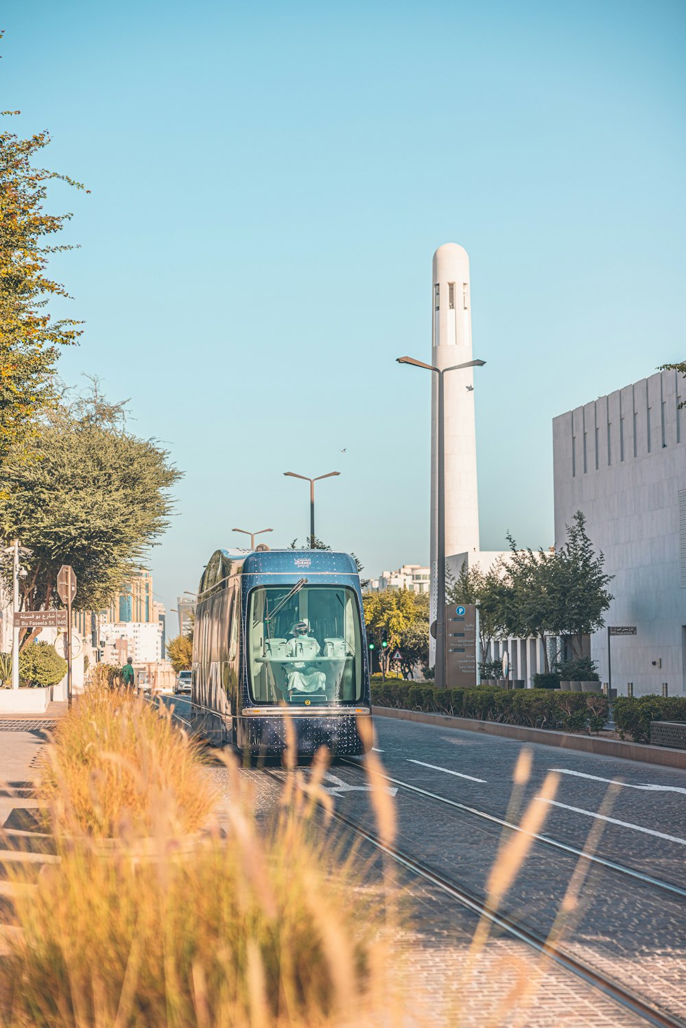 a bus driving down a street next to tall buildings